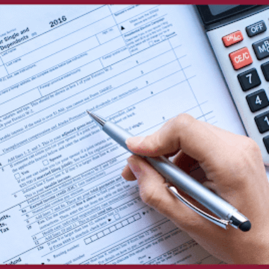 A person looking at paperwork and a calculator