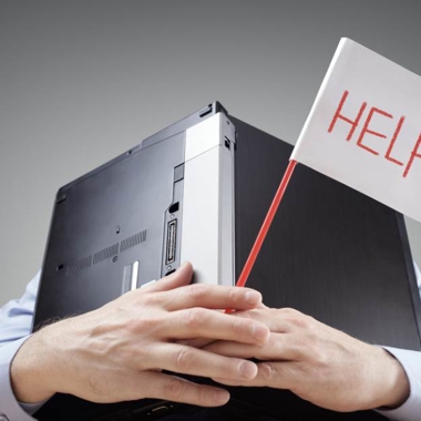 Businessman burying his head uner a laptop asking for help