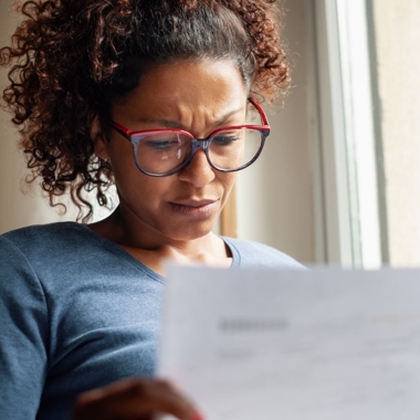 A women looking concerned at a letter