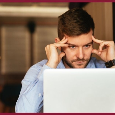 A stressed man looking at his computer