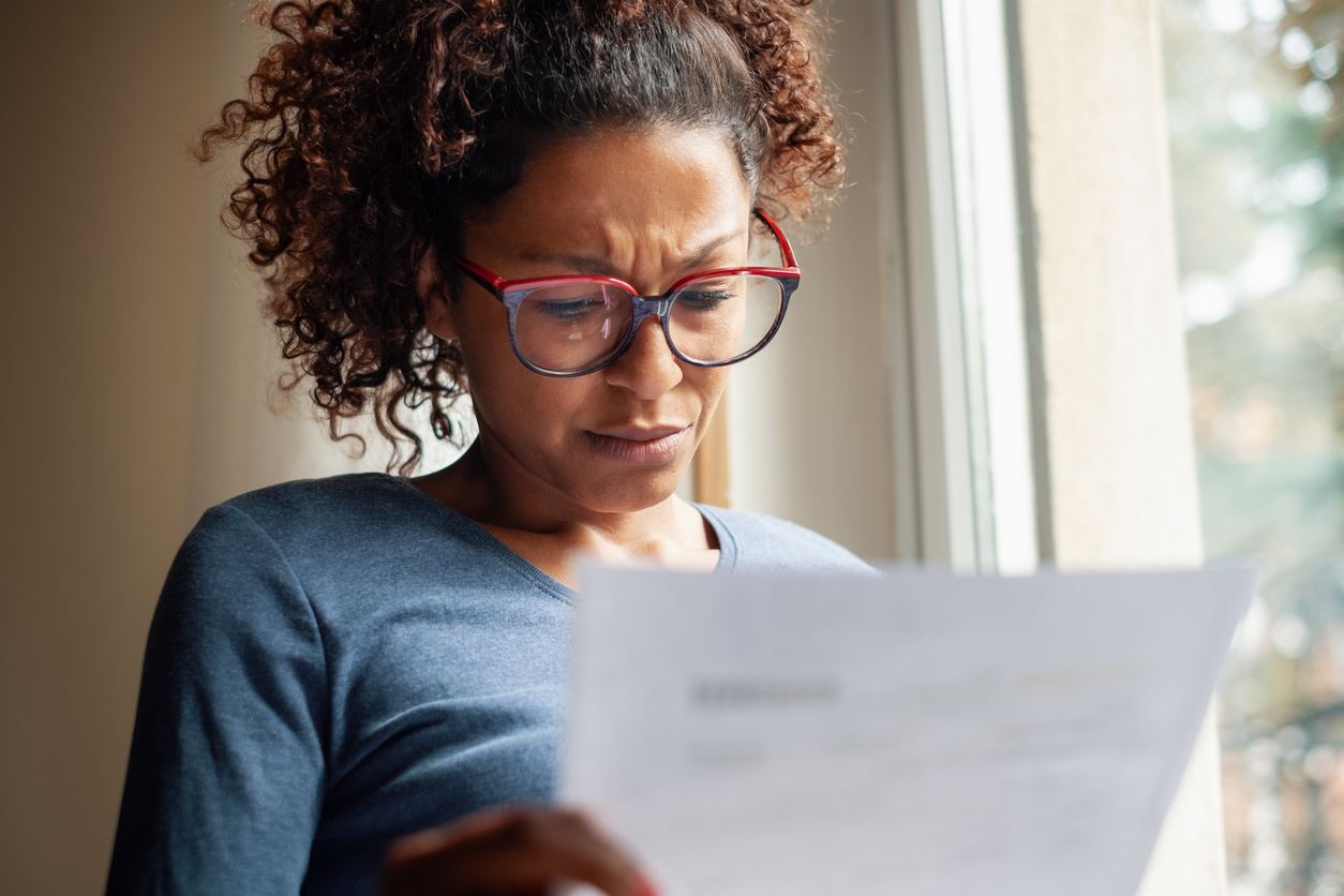 Woman worried looking at paperwork