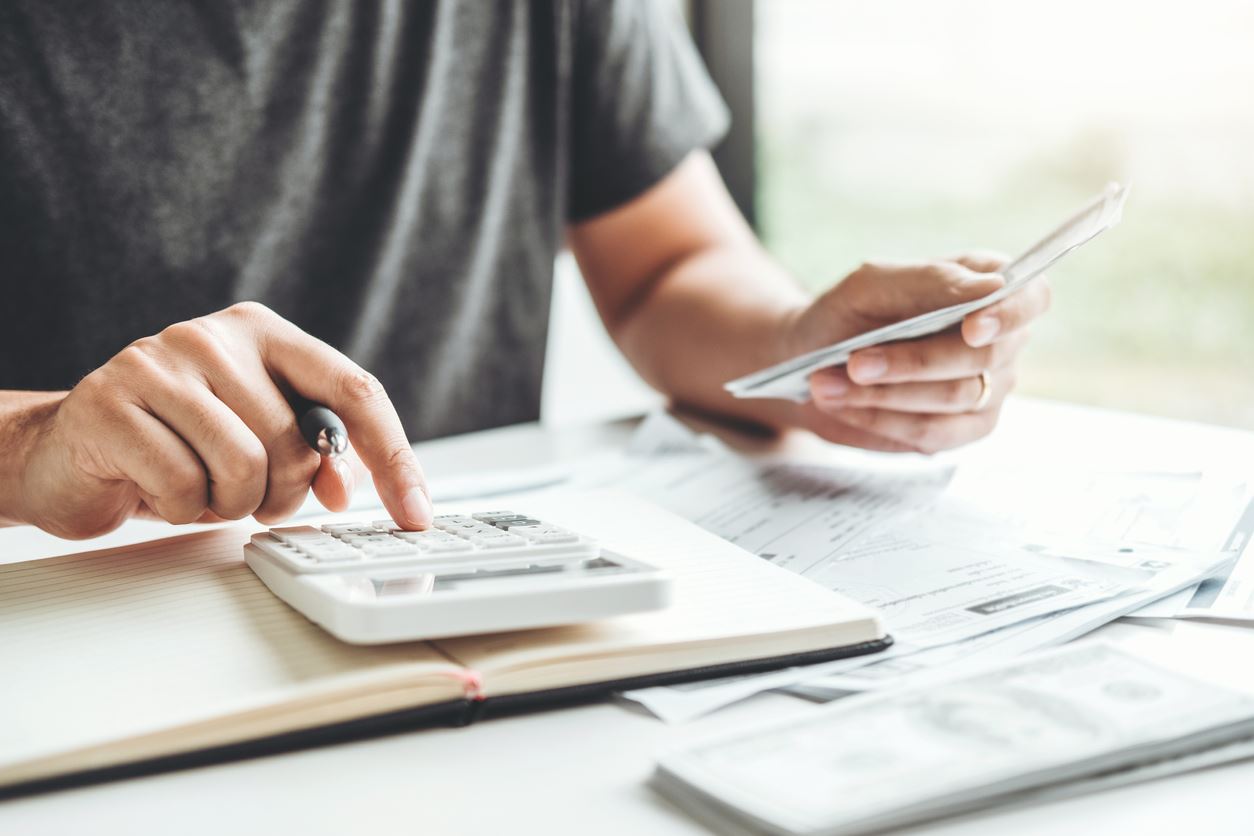 Man typing on a calculator doing finances.